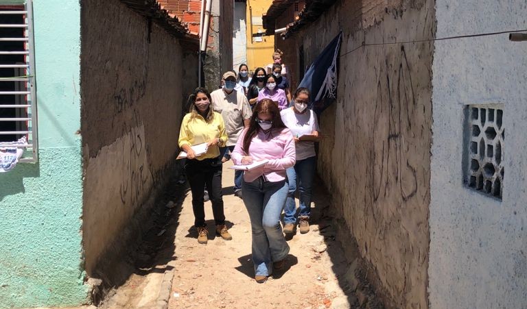 grupo de pessoas com máscara caminha em rua